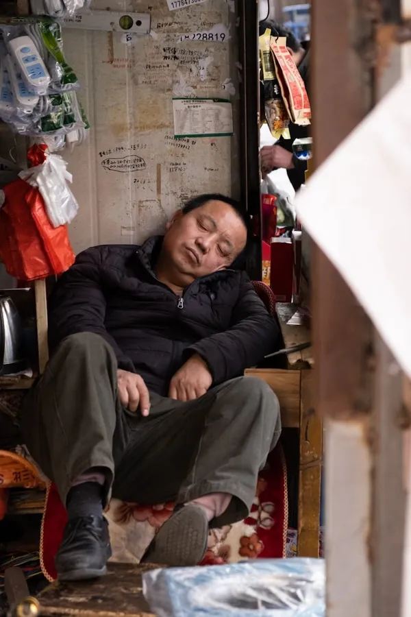 man in black jacket taking a nap at work